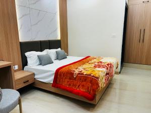 a bedroom with a bed with a red blanket at Hotel Rajasthan Inn in Behror