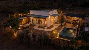 two elephants standing in front of a house at Elephantpoolvilla maetang Chiangmai in Ban Muang Kut