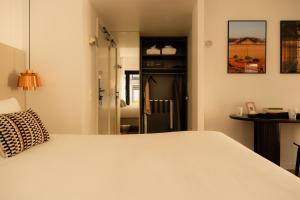 a bedroom with a white bed and a mirror at 9Hotel Sablon in Brussels +53 photos