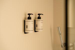 two bottles ofodorizers are hanging on a wall at 9Hotel Sablon in Brussels