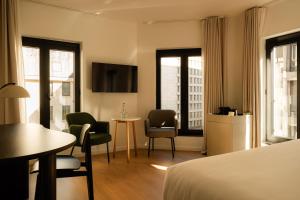 a hotel room with a bed and a table and chairs at 9Hotel Sablon in Brussels