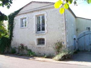una casa de ladrillo con una ventana y una puerta en Le Rosier, en Segonzac