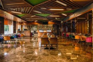 ein Restaurant mit Tischen und Stühlen in einem Raum in der Unterkunft Devka Beach Resort in Daman