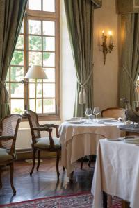 a dining room with two tables and chairs and a window at Château de Courcelles - Relais & Châteaux in Courcelles-sur-Vesle +27 photos