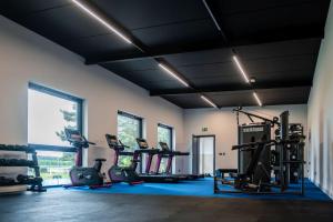 a gym with treadmills and elliptical machines at Błażejewko Resort in Błażejewko