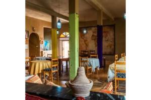 a room with tables and chairs and vases on a table at Gite Tamlli in Aoufous