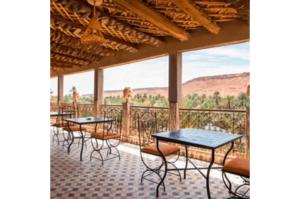 a row of tables and chairs on a balcony at Gite Tamlli in Aoufous