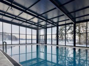 a swimming pool with snow on the ground and windows at Błażejewko Resort in Błażejewko
