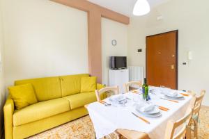 a living room with a table and a yellow couch at 62 - Accogliente a due passi dal mare in Silvi Paese