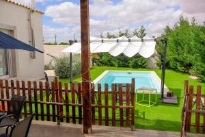 a fence with an umbrella and a swimming pool at Finca cataleya in Noez