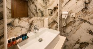 a white sink in a bathroom with a marble wall at Envoy Continental Hotel, Blue Area, Islamabad in Islamabad +60 photos