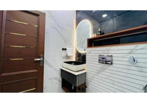 a bathroom with a sink and a wooden door at Olive Serviced Apartments - Central Delhi in New Delhi +35 photos