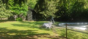 a bench sitting in the grass next to a swimming pool at Villa Ca' dei Tigli in Porretta Terme