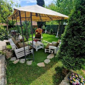 a gazebo with chairs and tables in a yard at Guest House Simon Green in Balchik