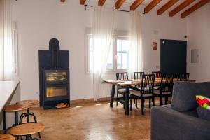 a living room with a table and chairs and a fireplace at Finca cataleya in Noez