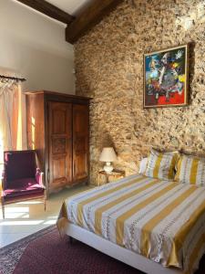 a bedroom with a bed and a stone wall at La Gran Vigne in Salernes
