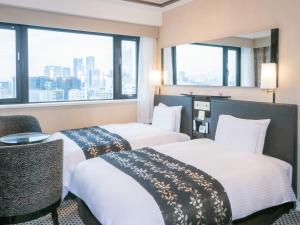 two beds in a hotel room with windows at APA Hotel Sugamo Ekimae in Tokyo