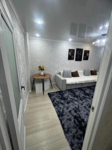 a living room with a couch and a table at Квартира 2 комнаты in Balqash +4 photos
