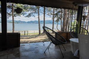 a patio with two chairs and a view of the water at Borova Bajka - Peace & Privacy by the Danube in Usije +30 photos