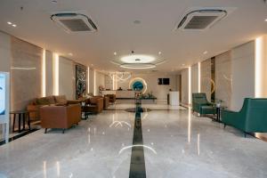 a lobby with couches and chairs in a building at Clarion Hotel Hyderabad in Hyderabad