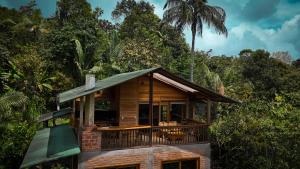 a small house with a balcony in the forest at LA RUSTICA MiNDO in Mindo