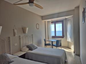 a bedroom with two beds and a table and a window at Hotel Maeva ,1 star B&B in Lloret de Mar +29 photos