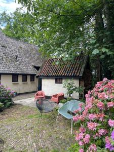 two chairs and a table in front of a house at B&B huize Stoutenburght in Blesdijke