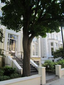 a tree in front of a white house at Belsize House (Belsize Park) in London