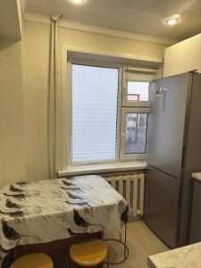 a small room with a bed and a window at Квартира 2 комнаты in Balqash