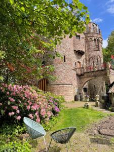 an old castle with two chairs in the yard at B&B huize Stoutenburght in Blesdijke +10 photos