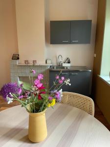 a yellow vase with flowers on a table in a kitchen at B&B huize Stoutenburght in Blesdijke
