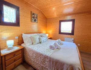 a bedroom with a bed in a wooden cabin at Casa da Covinha - Branda da Aveleira in Melgaço