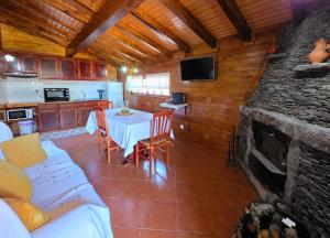a kitchen and dining room with a table and a fireplace at Casa da Covinha - Branda da Aveleira in Melgaço