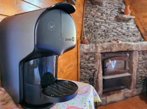 a coffee maker sitting on a table next to a fireplace at Casa da Covinha - Branda da Aveleira in Melgaço