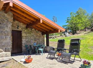a patio with chairs and a table in front of a building at Casa da Covinha - Branda da Aveleira in Melgaço