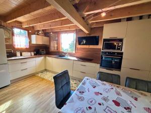 a kitchen with a table and chairs in a room at CONFORTABLE CHALET INDIVIDUEL SUR PYRENEES 2000 in Font-Romeu +7 photos