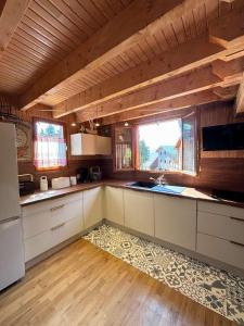 a kitchen with white cabinets and a large window at CONFORTABLE CHALET INDIVIDUEL SUR PYRENEES 2000 in Font-Romeu