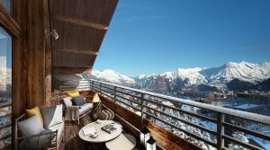 a balcony with a view of snow covered mountains at TERRESENS Le Caprice Blanc in La Toussuire