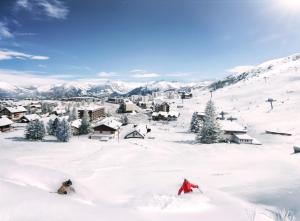 a group of people skiing down a snow covered mountain at TERRESENS Le Caprice Blanc in La Toussuire
