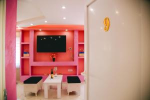 a room with a table and a tv on a wall at LUX apartman savić in Aleksinac