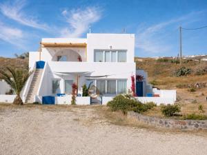 a white house in the middle of a field at Α Peaceful Seafront Escape in Santorini- Sonus Mare in Vourvoúlos