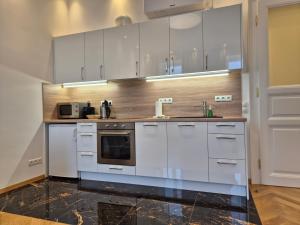 a kitchen with white cabinets and a sink at Apartment Nähe Zentrum in Vienna
