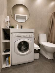 a bathroom with a washing machine and a toilet at Nazarbayev avenue central studios in Almaty +23 photos