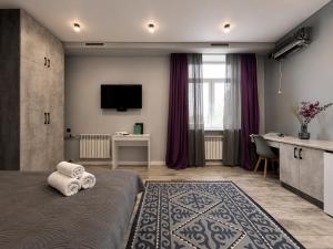 a hotel room with a bed with towels on it at Nazarbayev avenue central studios in Almaty