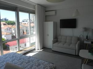 a bedroom with a couch and a large window at Bolhão Skyline in Porto