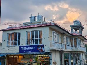 a white building with a sign in front of it at The Ooty Suites in Ooty