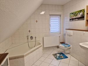 a bathroom with a tub and a toilet and a sink at Ferienwohnung Gretel in Görlitz