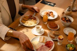 a table with plates of breakfast food on it at 9Hotel Sablon in Brussels
