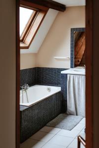 a bathroom with a bath tub and a sink at Haras de Baudemont in Ittre +12 photos