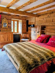 a bedroom with a large bed in a log cabin at L'Escale Pyrénéenne in Melles